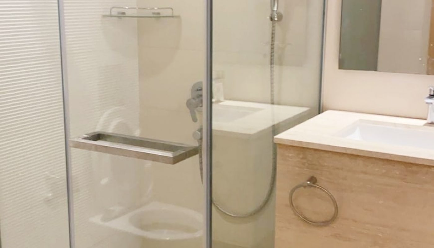 A fully furnished apartment for rent in Dilmunia featuring a glass shower stall and sink.