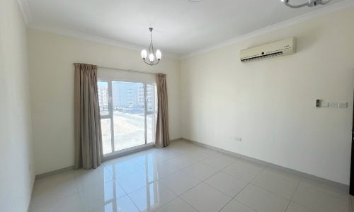 A furnished room with a window and a door.