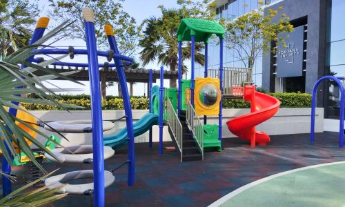 A spacious children's playground with colorful slides and swings.