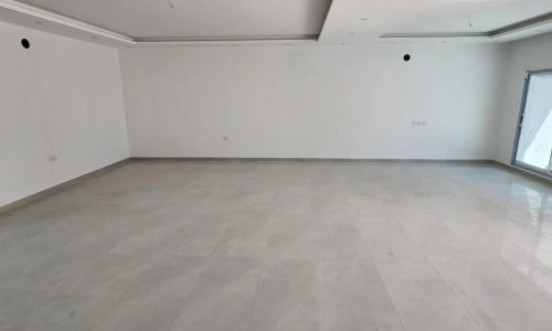 A large empty room with white walls and tile floors in a Luxury Villa for Sale in Bani Jamra | 1 Road.