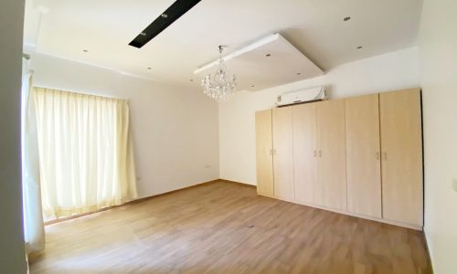 An empty luxury room with wooden floors.