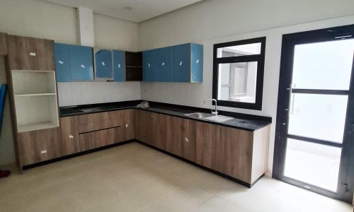 A brand new kitchen with blue cabinets and a door in a villa for sale in Barbar.