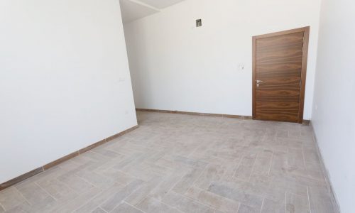 Empty room with wooden floor and wooden door.