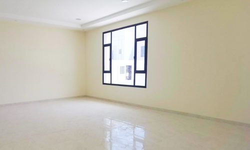 An empty room with white tile floors, a window, and a modern design.