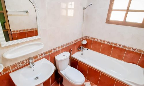 A 4-bedroom villa in Janabiyah featuring a bathroom with sink, toilet, and tub.