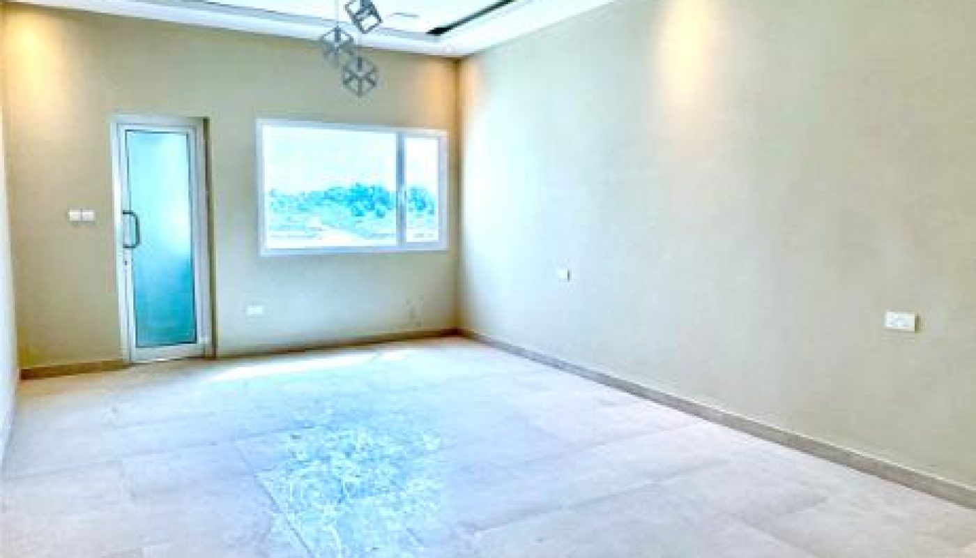 Empty room with beige tiled floor, cream walls, a window, a glass door, and a modern geometric ceiling light fixture.