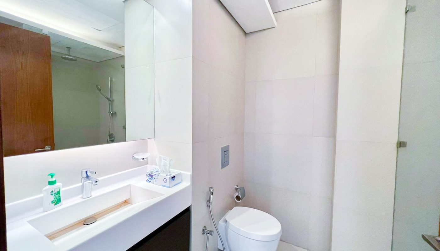 A luxury bathroom with a toilet, sink and mirror.