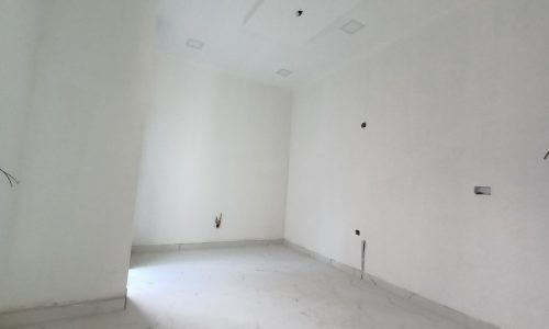 A luxurious villa for sale in Barbar with white walls and a ceiling fan.