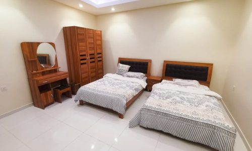 A luxury 3BR apartment for sale with a bedroom furnished with two beds and a dresser.