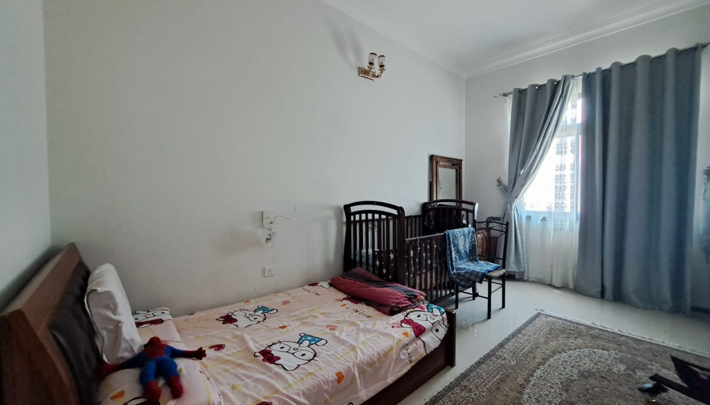 A furnished bedroom with a bed and a bedside table.