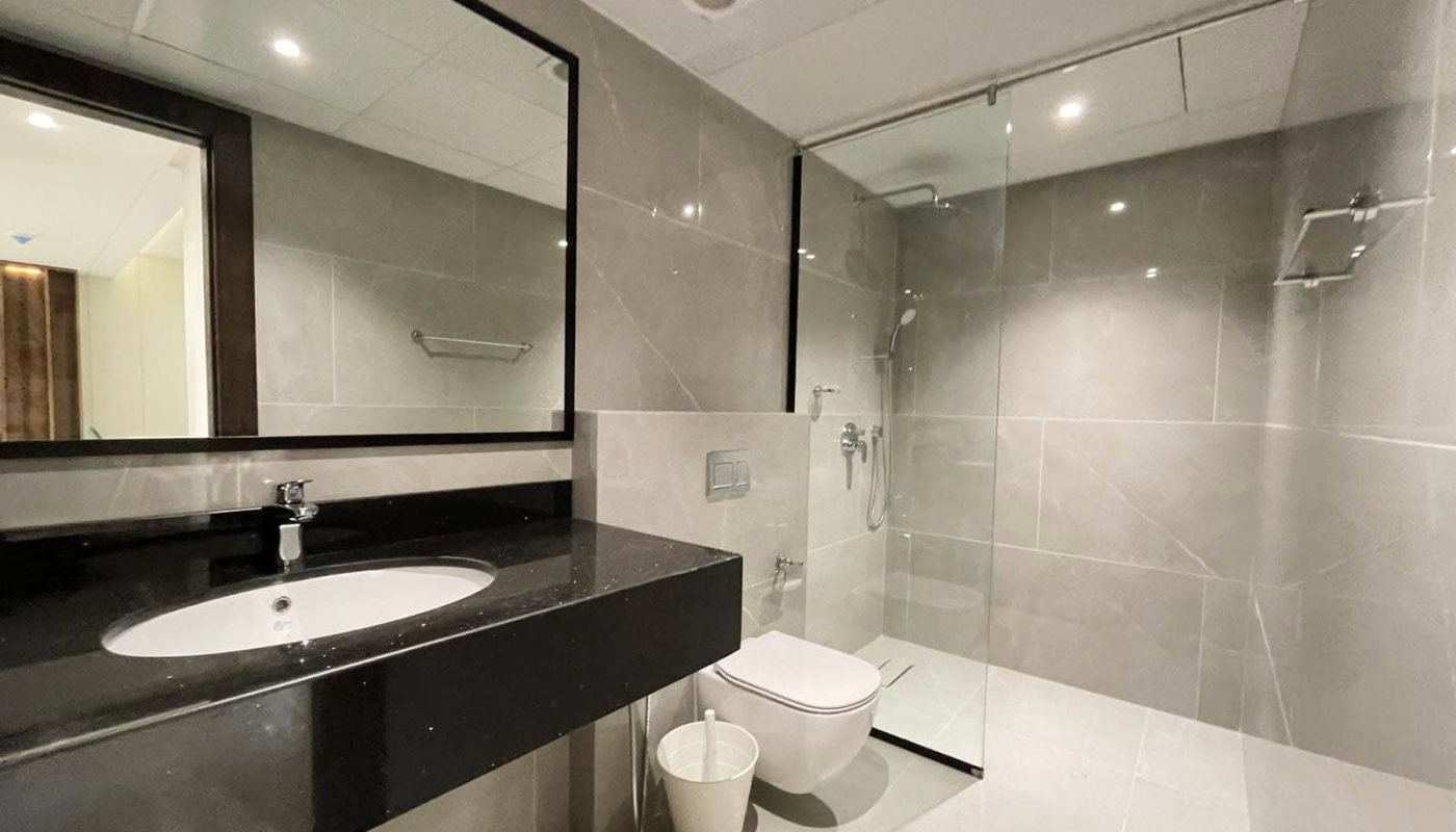 A modern bathroom with a large mirror and sink, featuring an Auto Draft system for enhanced ventilation.