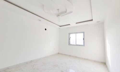 This white-walled room in a luxury apartment in Riffa features a ceiling fan.