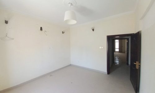 A building for sale: an empty room with a ceiling fan and white walls in Juffair.