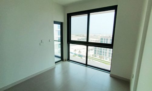 A stunning empty room with sliding glass doors and a view of the city in Diyar Al Muharraq.