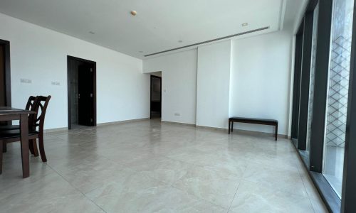 A luxurious apartment with large windows and a spacious dining table.