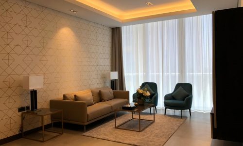 A modern living room with a sofa, chairs and a coffee table.