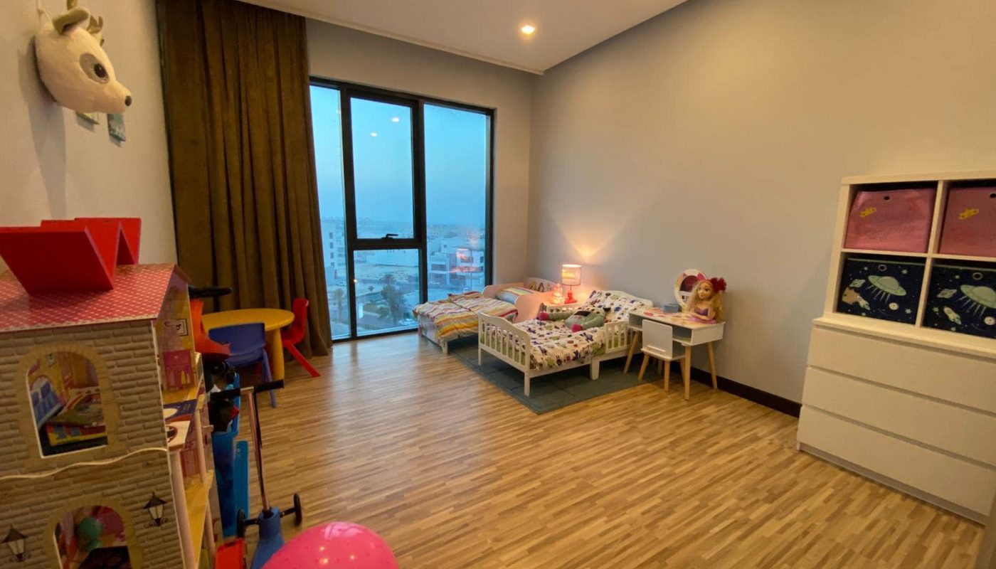 Description: An amazing apartment with a child's room filled with toys and a view of the city.