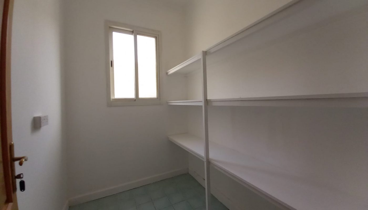 A small room with shelves and a window.