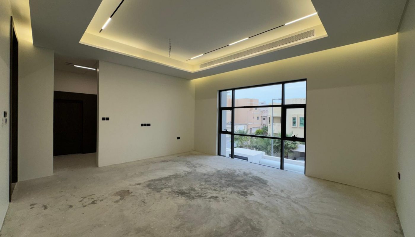 Unfurnished room with unfinished concrete floor, recessed ceiling lights, large windows, and a view of neighboring buildings.