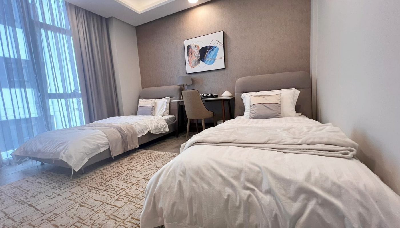 Luxurious flat for sale with two beds in a bedroom, showcasing a large window.