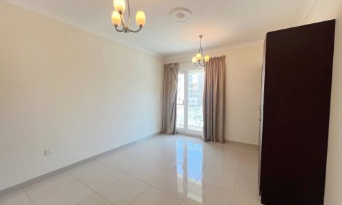 A furnished room with a door and a closet.