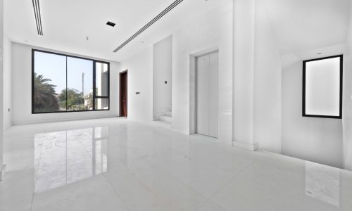 An empty white room with large windows.