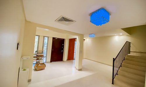 A luxury villa with a blue light fixture in the hallway, featuring a garden, is for sale in Saraya 2.