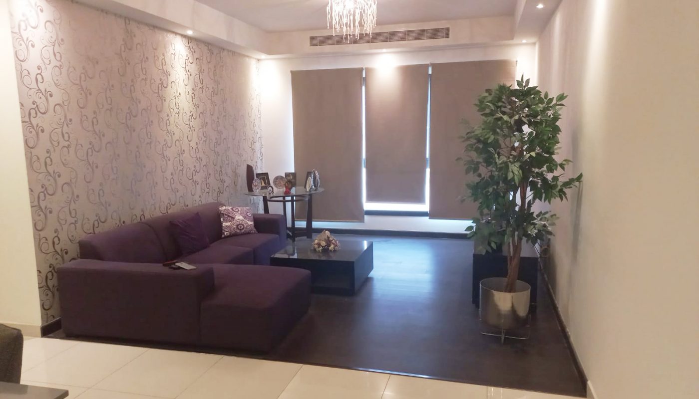 A luxurious living room with a purple couch and a coffee table.