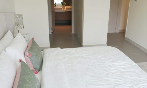 An apartment in Marassi available for rent, featuring a white bed in the bedroom.