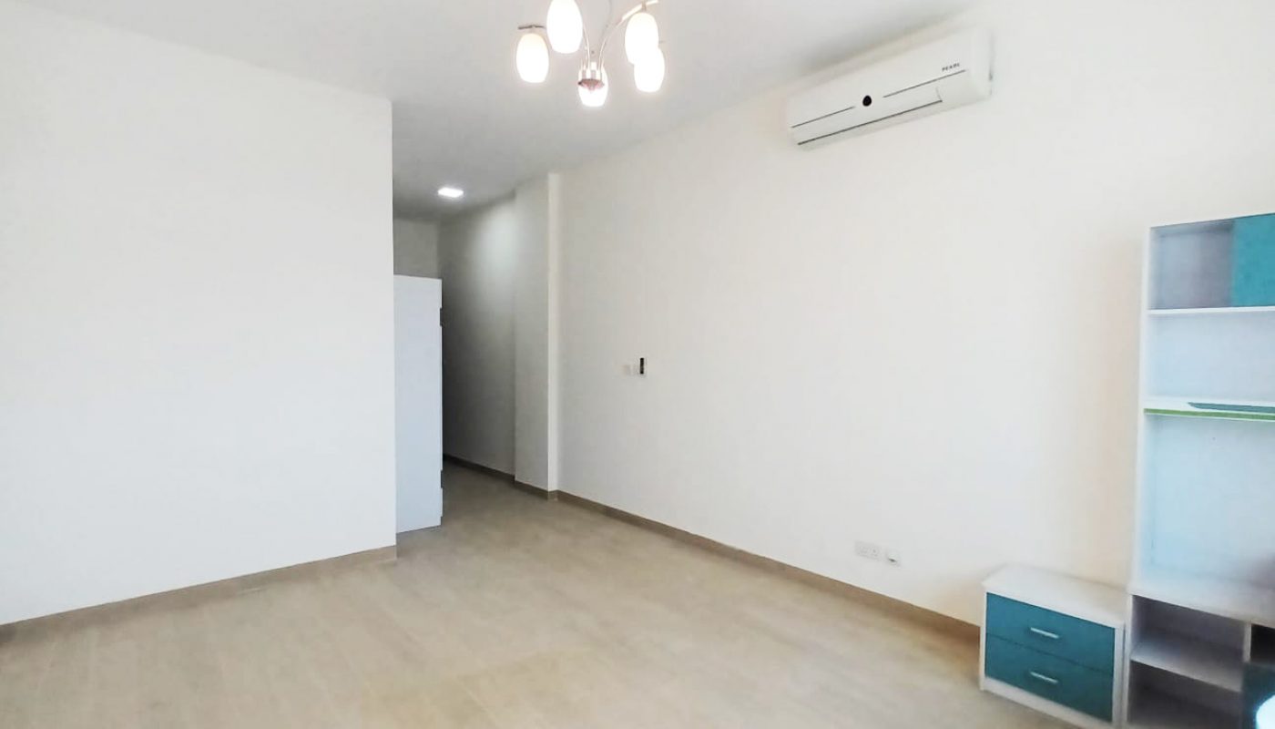 Spacious luxury apartment for rent with a bed, a desk, and a refrigerator in Seef.