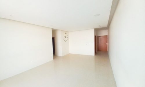 A spacious apartment with three bedrooms, featuring an empty room with pristine white walls and floors.