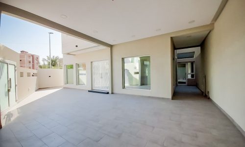 A luxurious villa for sale in Bu Quwah with a tiled floor and a glass door.