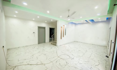 A spacious room with white walls and marble floors.