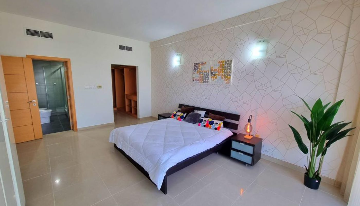 Immaculate bedroom with bed and bedside table for sale in Amwaj Island.