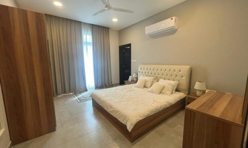 A modern bedroom with a bed and a ceiling fan.