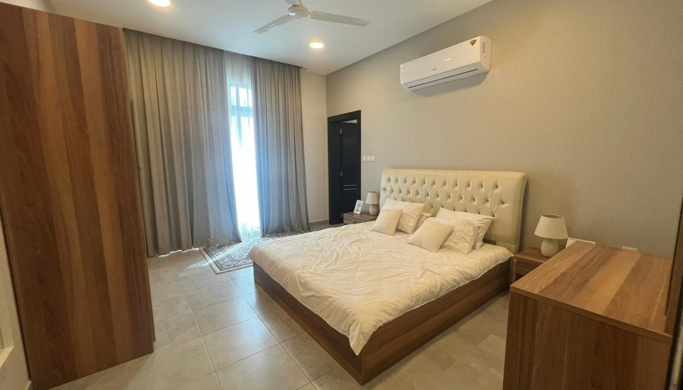 A modern bedroom with a bed and a ceiling fan.