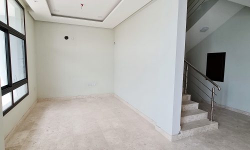 A brand new villa for sale in Barbar featuring a large empty room with stairs and windows.