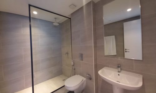 A luxury flat for rent in Seef with glass shower door and sink.