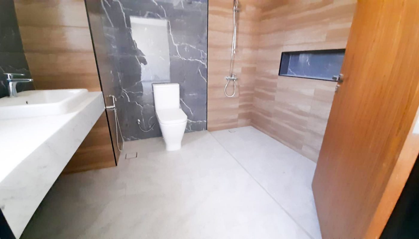 Luxury bathroom with a toilet, sink and mirror.