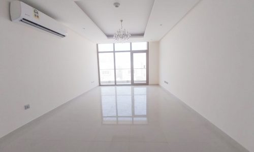 A spacious two-bedroom apartment available for rent, featuring an empty room with a large window and air conditioning.