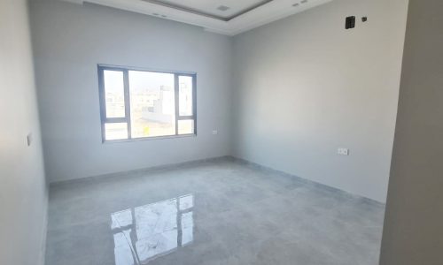 A brand new villa for sale, featuring an empty room with white walls and a window.