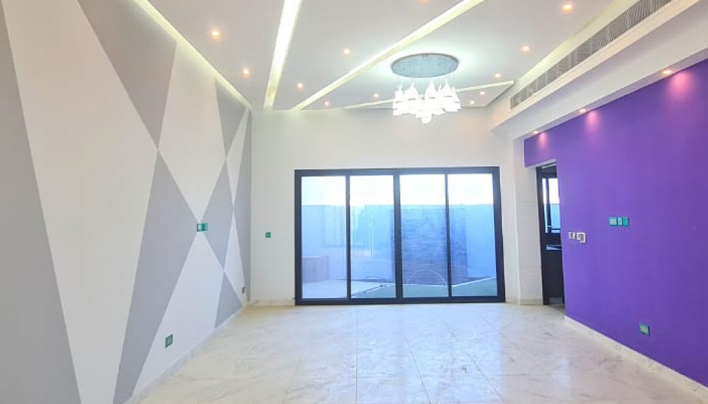 A luxurious empty room with purple walls and marble floors in a 3BR villa for sale in Sitra.