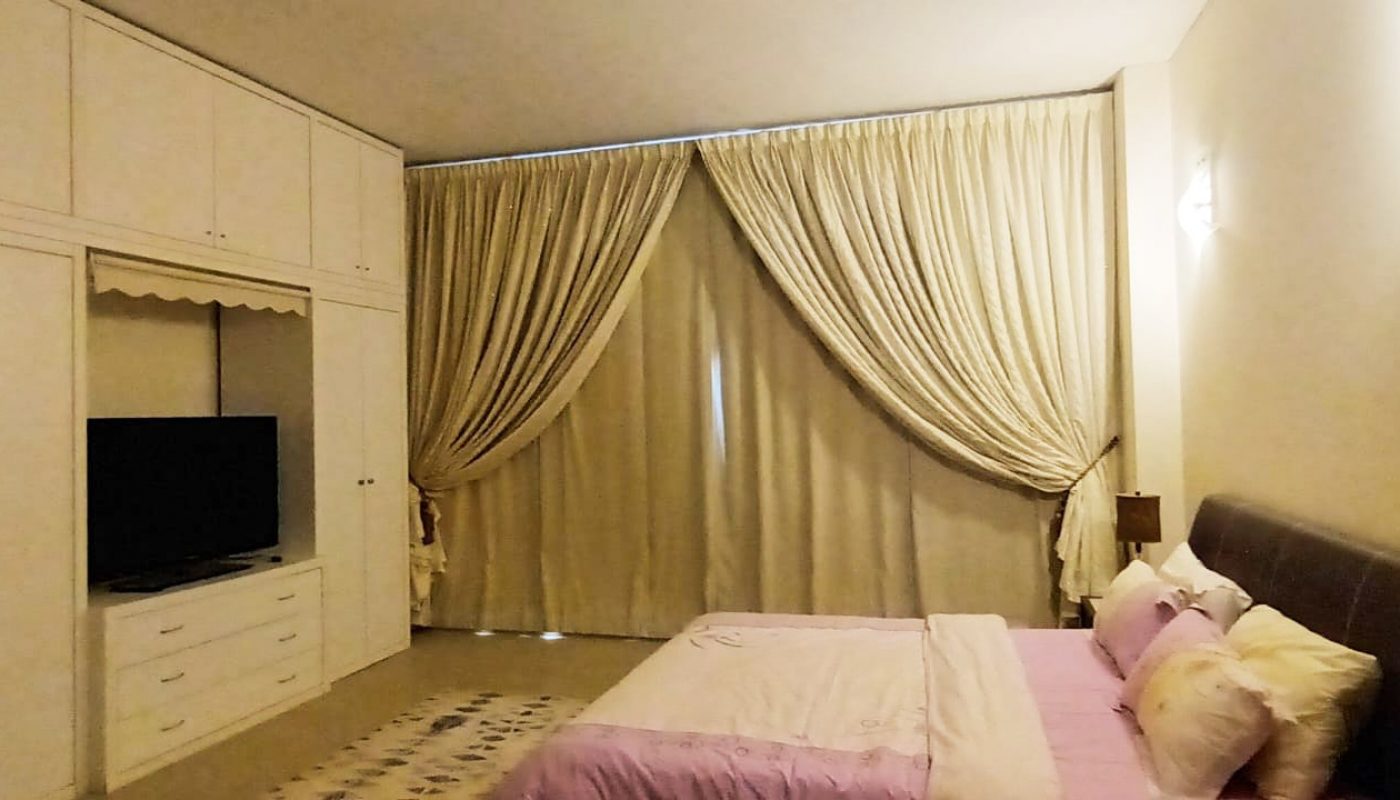 A modern bedroom with a bed and dresser.