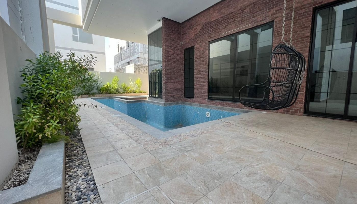 A luxurious swimming pool in the backyard of a huge villa.