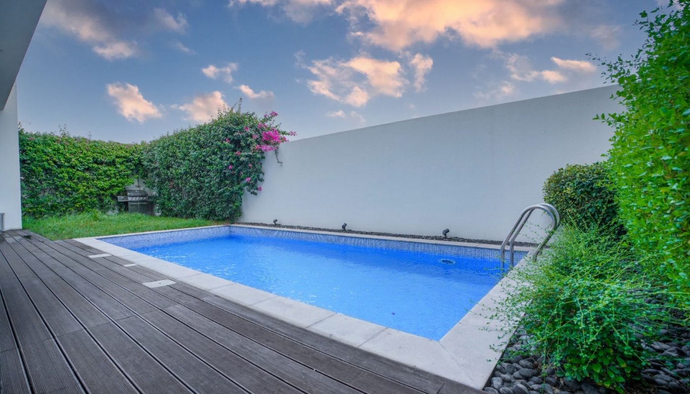 An eye-catching backyard swimming pool featuring a wooden deck.