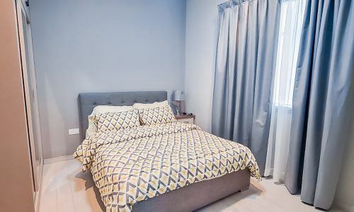 A small bedroom with curtains in a Luxurious 4BR Villa for Rent in Diyar Al Muharraq