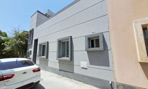 A cozy house with a car parked in front of it.