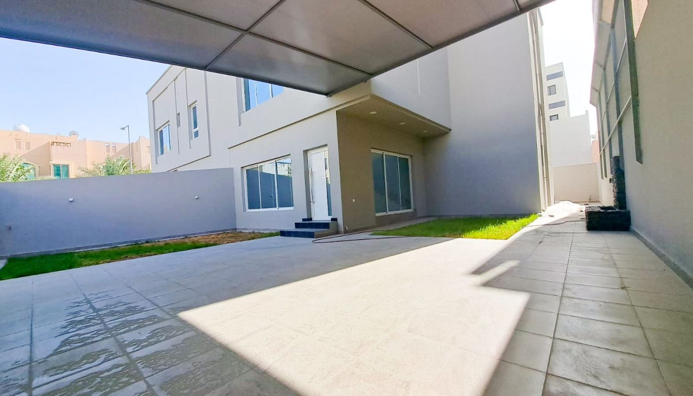 A Luxury 4BR Villa in the middle of a courtyard with a grassy area, available For Sale.