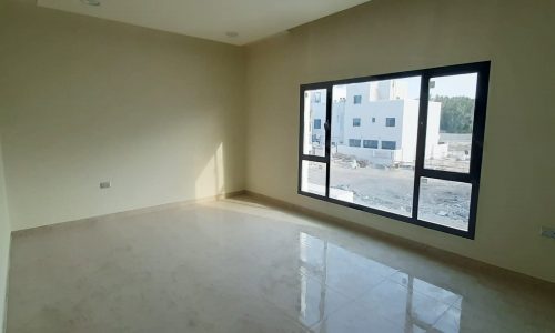 A large empty room with a large window in an amazing villa.