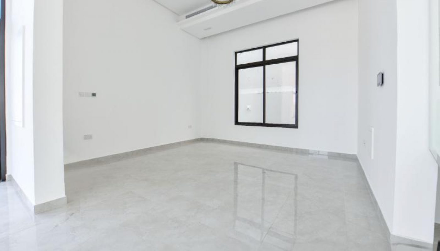 Empty, unfurnished room with glossy tiled floor, white walls, a large window, and a modern ceiling light fixture.